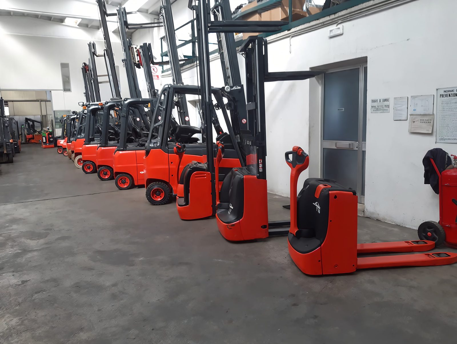 Carrelli elevatori e transpallet Linde revisionati in fila nel capannone